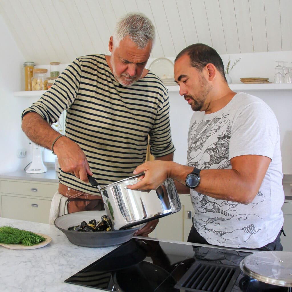 Ernst Kirchsteiger och Mikael Göransson häller mat ur en kastrull
